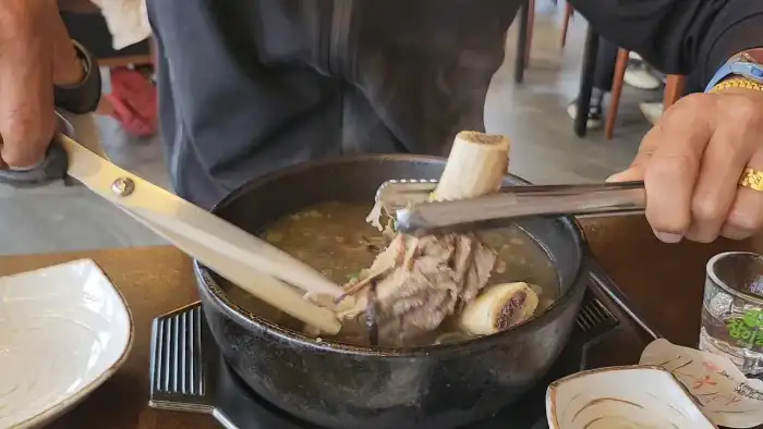 집게로 큼지막한 갈빗대를 집어 올리는 모습