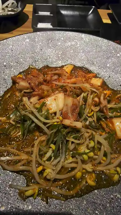 김치, 콩나물, 대파 등이 함께 볶아져 소스가 자작하게 어우러진 대패삼겹살