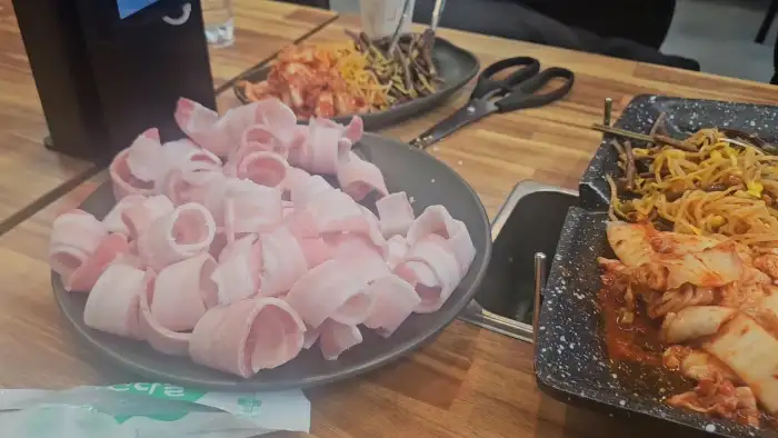 신선해 보이는 대패삼겹살이 접시에 담겨 있는 모습