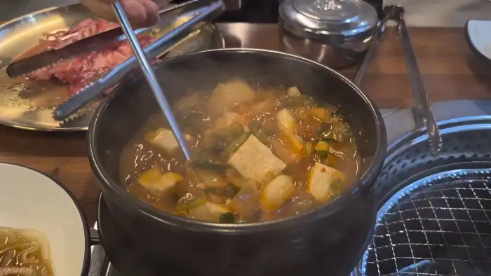 양념 갈비살을 집게로 뒤집는 모습.