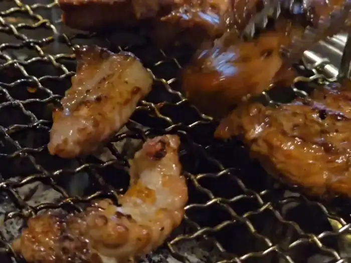 직원이 집게로 고기를 뒤집는 모습