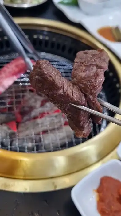집게로 집어 올린 한우 덩어리