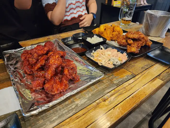 테이블에 차려진 다양한 치킨 메뉴와 곁들임 음식