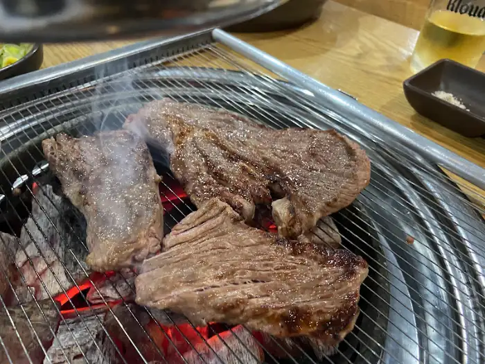 숯불 위에서 더욱 맛있게 익어가고 있는 소고기 조각들. 김이 모락모락 납니다.