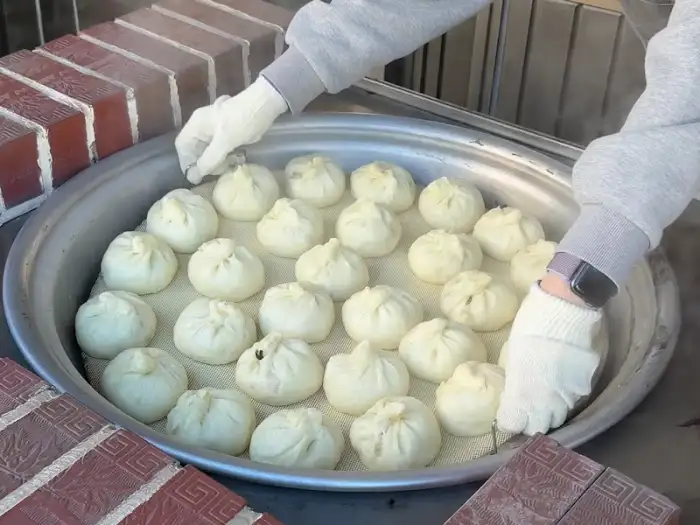 두 손으로 찐빵을 조심스럽게 집어 올리는 모습