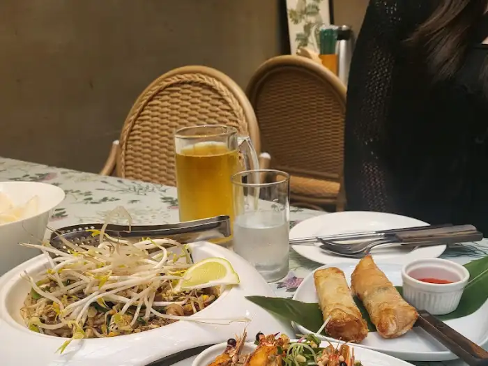 테이블에 놓인 팟타이, 스프링롤, 맥주, 음료수
