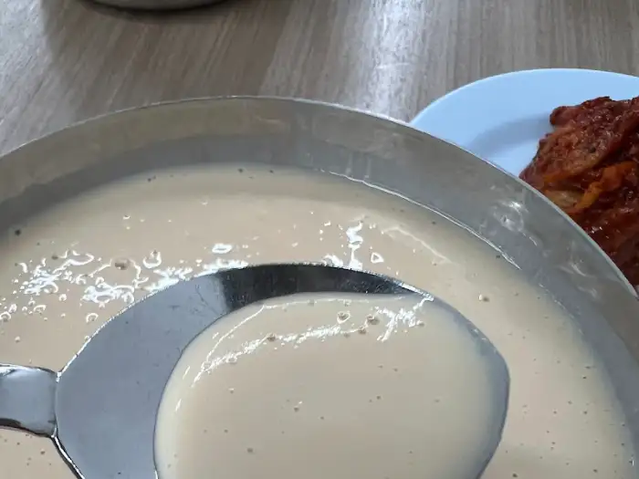 콩국수를 뜨기 위한 국자가 콩국물에 담겨 있는 모습