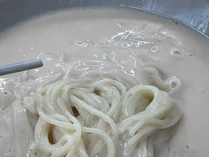 콩국수 면발에 콩국물이 묻어 있는 모습