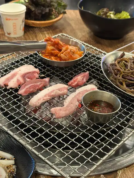 불판 위에서 구워지는 뒷고기 한 점