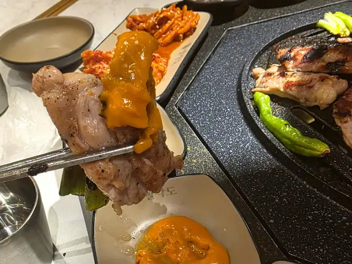 닭갈비 구이에 소스를 곁들여 먹는 모습