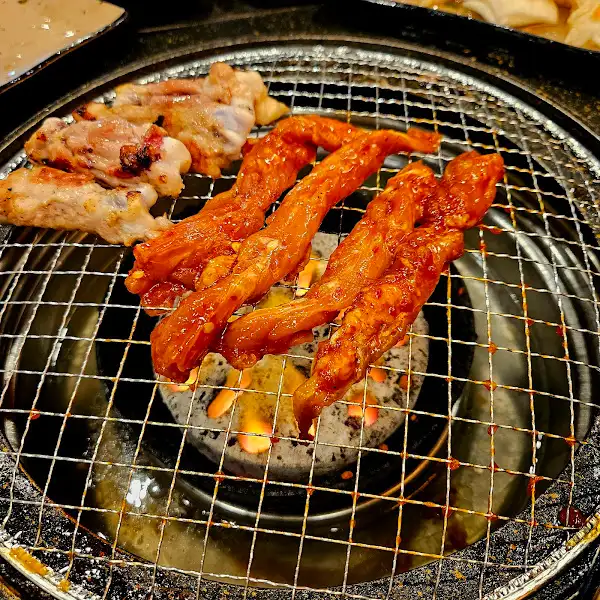 숯불 위에서 익고 있는 양념된 닭고기