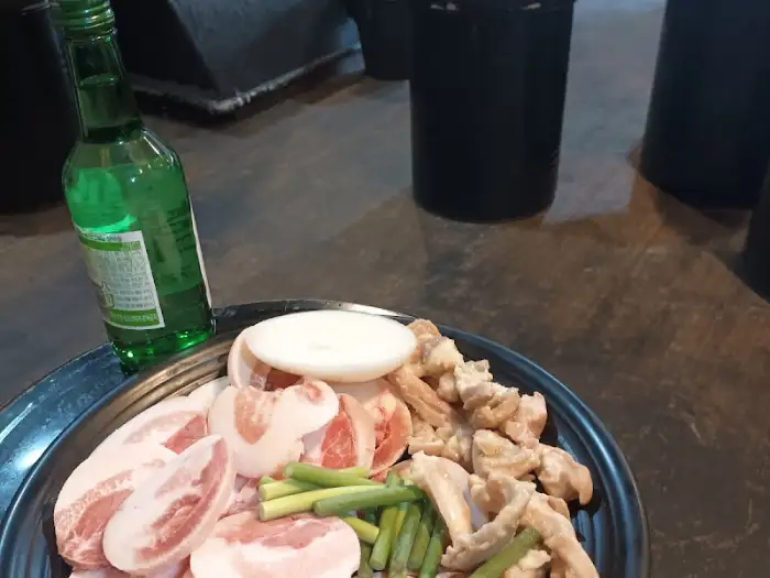 싱싱한 뽈항정살, 막창, 돼지껍데기가 한 접시에 담겨 나오고, 소주 한 병이 함께 놓여 있다.