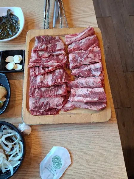 나무 도마 위에 가지런히 놓인 두툼한 갈빗살의 모습.