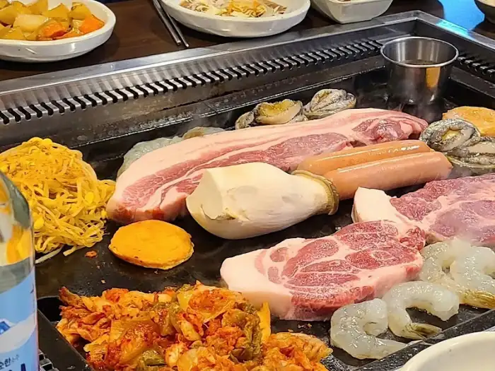 다양한 해산물과 흑돼지가 함께 구워지는 모습
