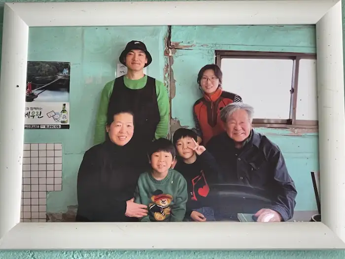 가족사진 액자. 젊은 시절 사장님과 아들, 손주 모습이 담겨 있다.