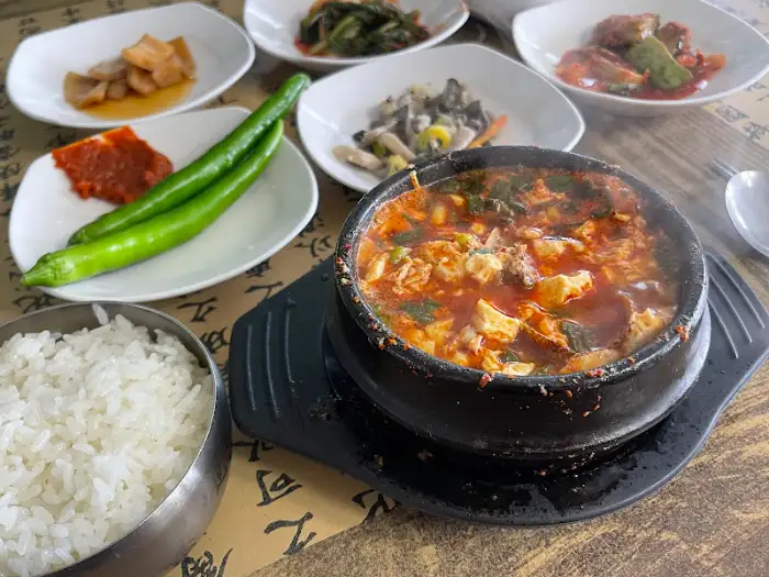 밥과 순두부찌개, 그리고 여러 가지 반찬이 정갈하게 차려진 모습.
