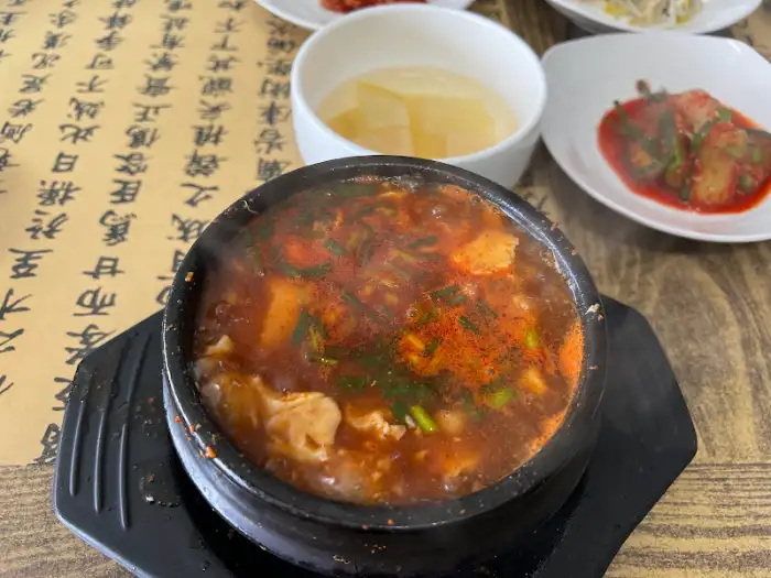 김이 모락모락 나는 순두부찌개 클로즈업 사진. 뚝배기에 담겨 나온다.
