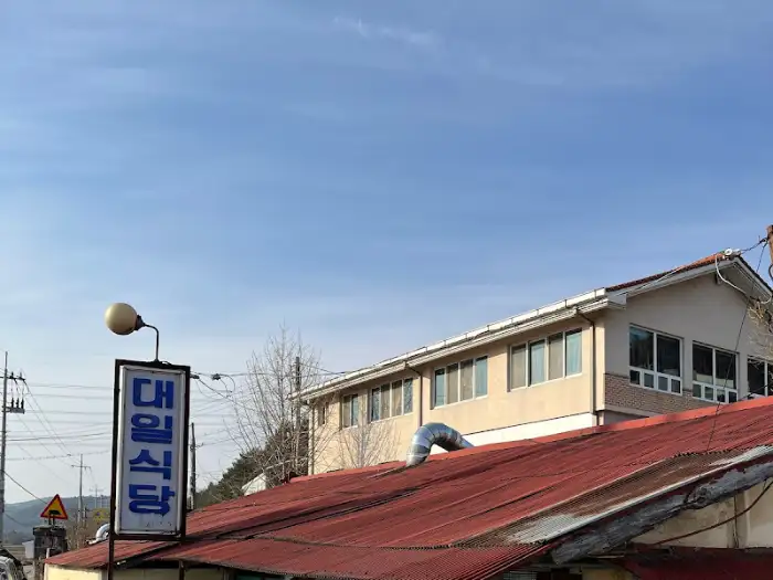 식당 지붕 너머로 보이는 파란 하늘과 대일식당 간판.
