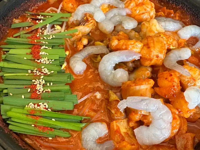 곱도리탕 클로즈업 모습, 푸짐한 곱창과 부드러운 대창, 싱싱한 대파와 고추가 어우러진 먹음직스러운 비주얼