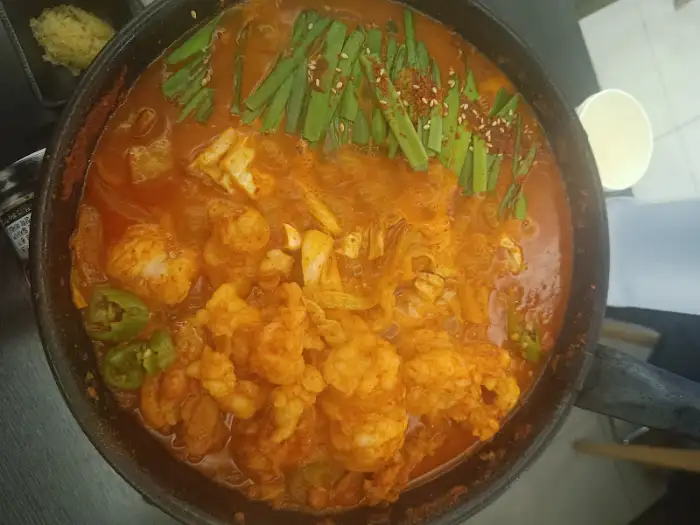 곱도리탕이 끓고 있는 모습, 붉은 국물에 다양한 재료들이 담겨 있으며, 끓이면서 더욱 맛있어 보입니다.