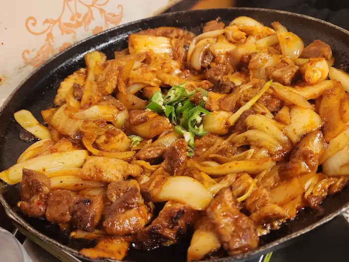 깻잎쌈에 돼지김치구이와 다양한 재료를 얹어 먹는 모습