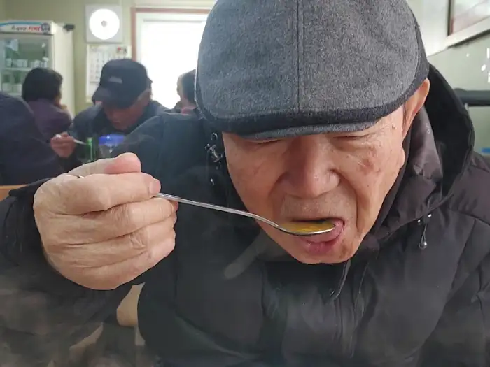 음식을 맛보는 어르신의 모습