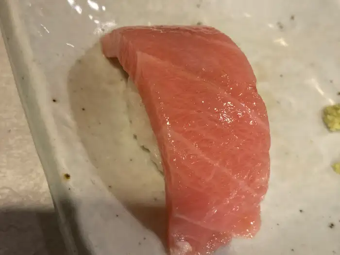 숙성 참치 한 점을 쥐고 있는 손