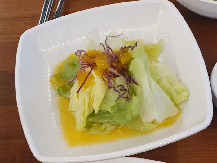 신선한 샐러드 위에 드레싱이 뿌려져 있는 모습