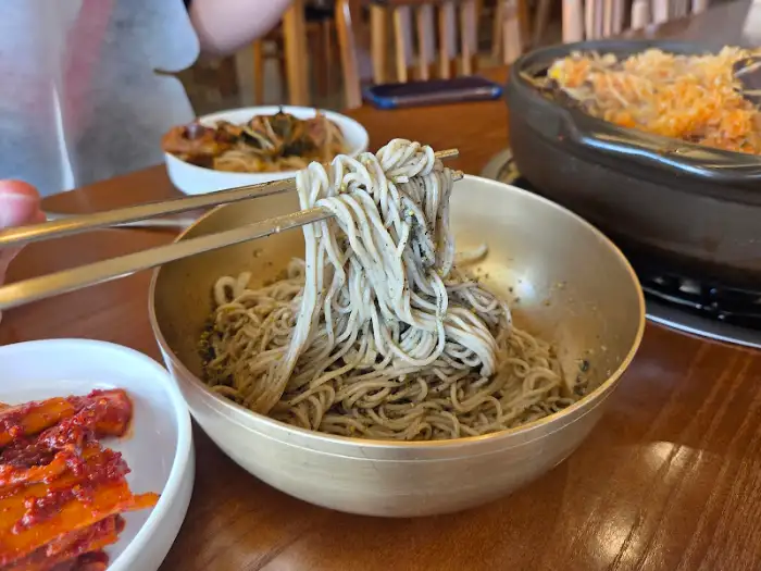 들기름 막국수를 집어 올리는 모습