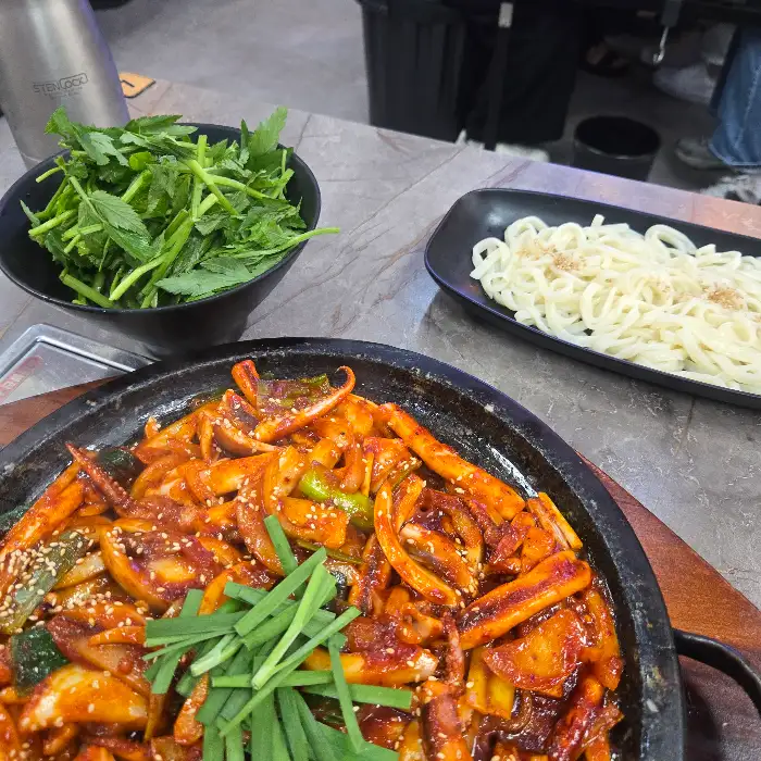 오징어 요리와 함께 곁들여 먹기 좋은 신선한 채소와 쫄깃한 면