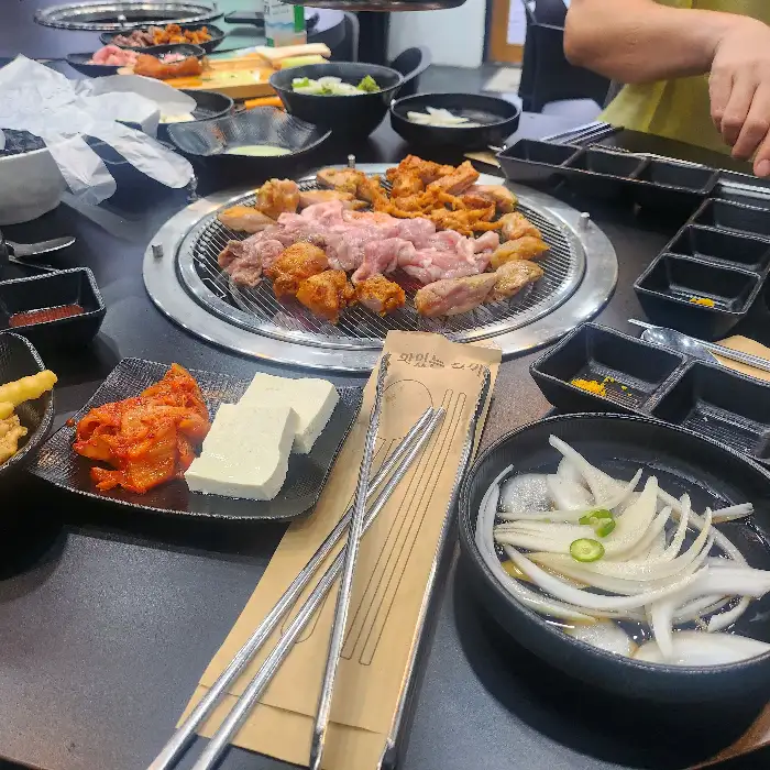 테이블에 차려진 푸짐한 닭갈비와 곁들임 메뉴들