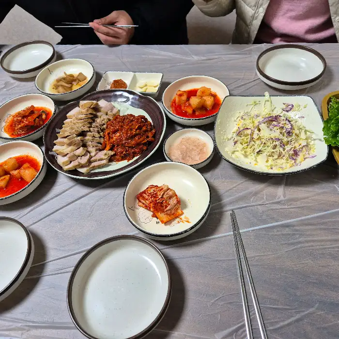 김치와 쌈 채소, 마늘 등이 담긴 여러 개의 작은 접시들