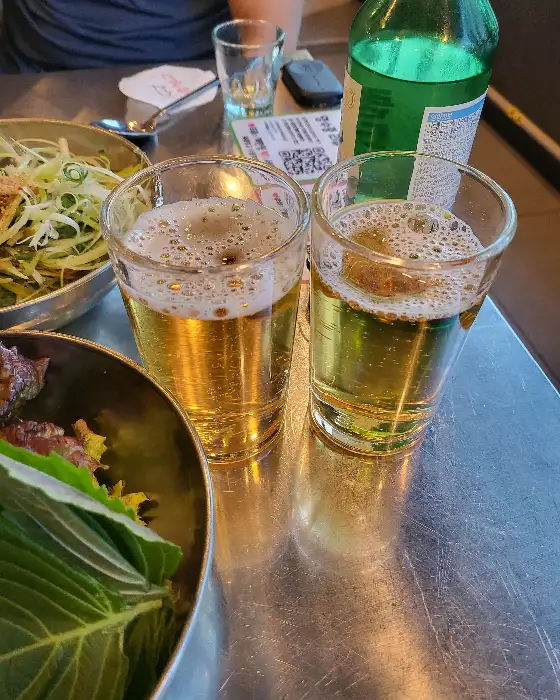 시원한 맥주가 담긴 두 잔의 잔이 테이블 위에 놓인 모습