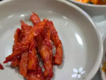 옥천골한정식의 다양한 반찬 중 하나인 붉은 양념의 요리