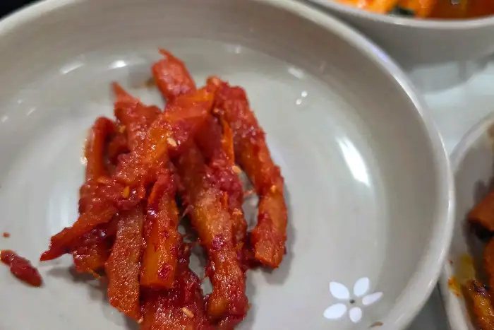옥천골한정식의 다양한 반찬 중 하나인 붉은 양념의 요리