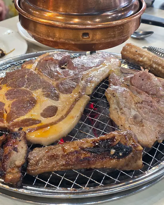 명륜진사갈비 김해장유점의 숯불 위에서 구워지고 있는 다양한 고기