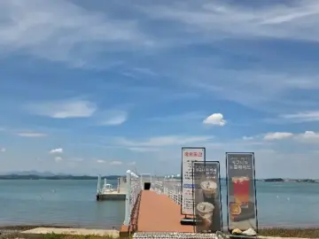 사천 씨맨스 카페로 이어지는 붉은색 나무 데크와 푸른 바다 풍경