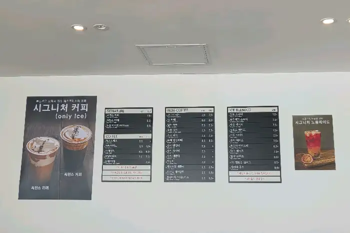 씨맨스 카페 내부 벽에 걸린 메뉴판과 시그니처 메뉴 포스터