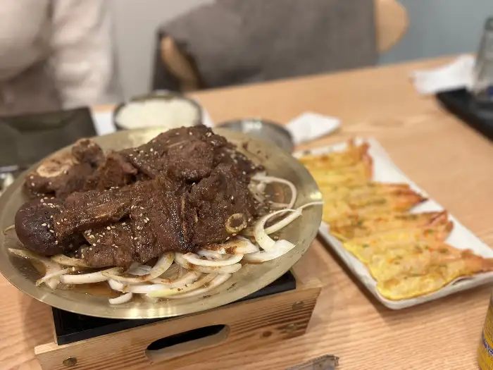 진한 양념으로 조리된 갈비찜과 신선한 참치회가 함께 차려진 식탁
