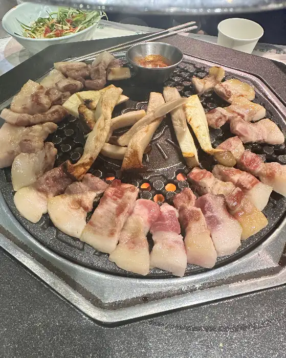 제줏간 전주혁신도시점의 쫀득살과 삼겹살이 불판 위에서 노릇하게 구워지고 있는 모습