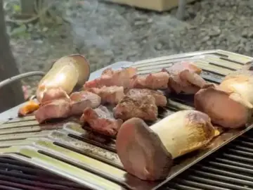 산앤들 야외에서 구워지고 있는 두툼한 고기와 새송이버섯
