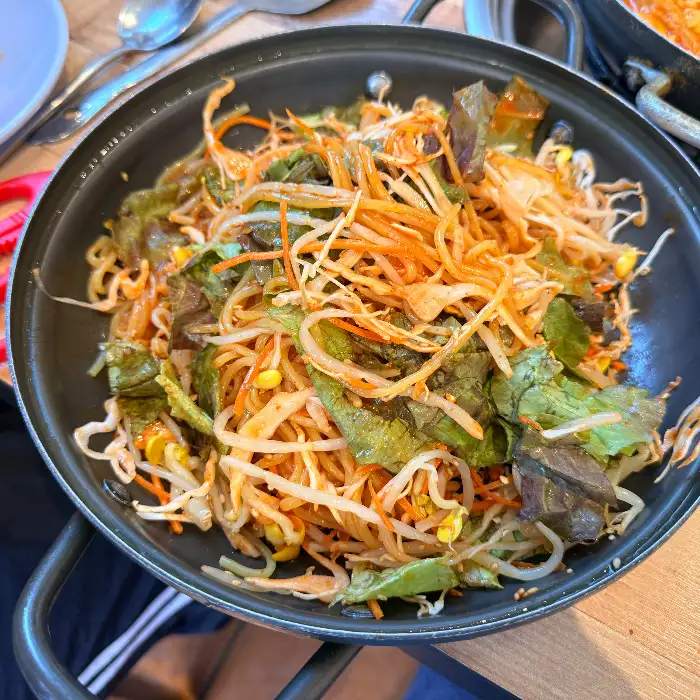 신선한 채소와 면이 어우러진 비빔만두