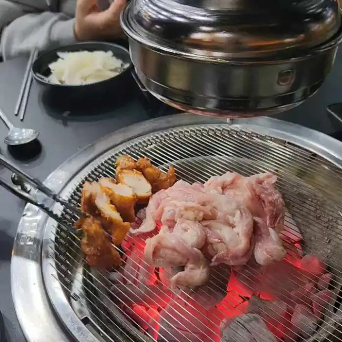 숯불 위에서 맛있게 익어가는 닭고기와 닭목살