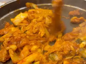춘천명물닭갈비: 춘천 맛집, 푸짐함과 친절함으로 채우는 완벽한 식사 춘천명물닭갈비 철판 위 닭갈비와 떡, 양배추가 볶아지고 있는 모습