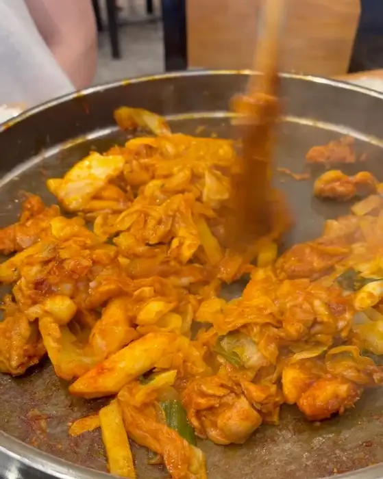 춘천명물닭갈비 철판 위 닭갈비와 떡, 양배추가 볶아지고 있는 모습