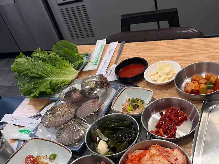 다양한 쌈 채소와 곁들임 찬들이 푸짐하게 차려진 모습