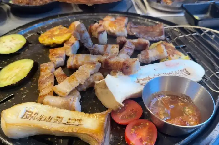 잘 구워진 삼겹살과 곁들여 먹는 가지, 버섯, 토마토