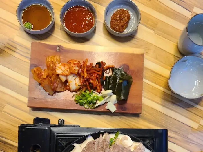 세 가지 소스와 곁들임 반찬, 그리고 수육을 준비하는 모습