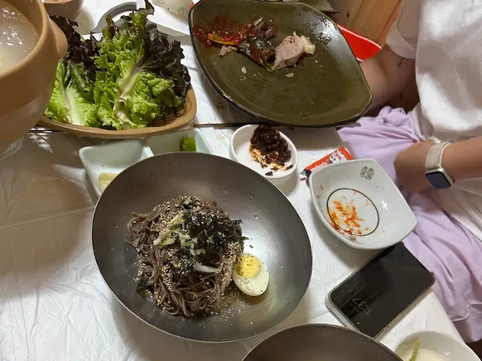 봉평메밀막국수냉면의 메밀막국수, 고명과 함께 제공
