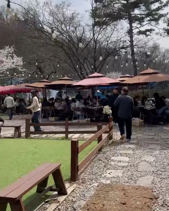 산앤들 야외 공간에 마련된 많은 테이블과 우산들